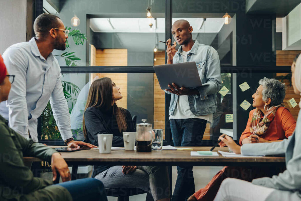 diverse business professionals having a discussion during a meeting in a modern office. team of multicultural businesspeople sharing creative ideas in an inclusive workplace.